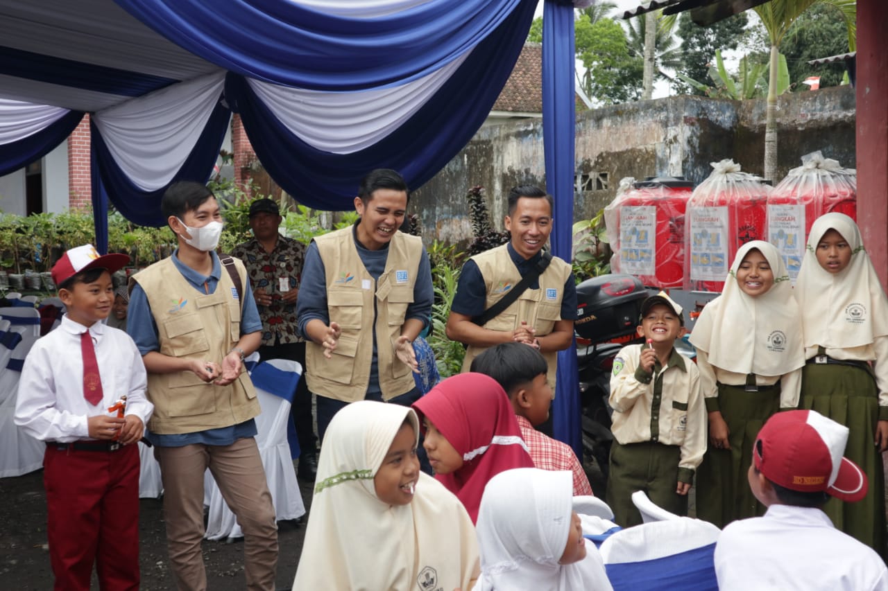 Para karyawan BFI Finance berinteraksi dengan anak-anak terdampak erupsi Semeru